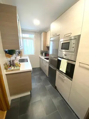 a kitchen with a stainless steel refrigerator and cabinets at APTO CÉNTRICO ARENAL FAMILY, PARKING GRATIS in Lugo
