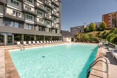 a large swimming pool in front of a building at Exe Peregrino in Santiago de Compostela