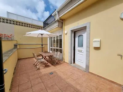a patio with a table and chairs and an umbrella at Terrazas del Cantábrico in Foz