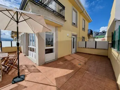 a patio with an umbrella and a table and chairs at Terrazas del Cantábrico in Foz