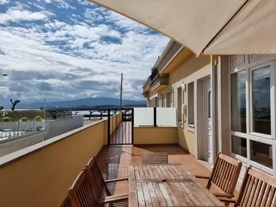 a balcony with a table and chairs on a building at Terrazas del Cantábrico in Foz