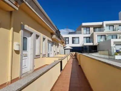 a balcony of a building with yellow walls and windows at Terrazas del Cantábrico in Foz