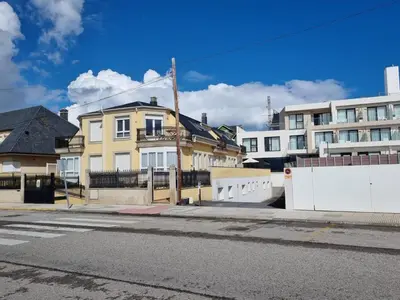 an empty street with a yellow house and some buildings at Terrazas del Cantábrico in Foz