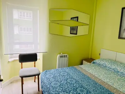 a bedroom with a bed and a chair and a window at Viveiro-Lugomar in Viveiro