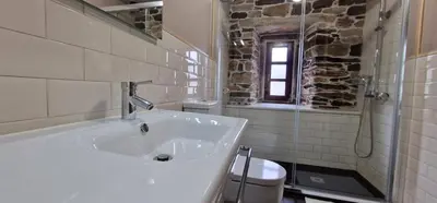 a white bathroom with a sink and a window at Habitaciones La Cuevona de Guitiriz,Parga, en el camino norte Lugo in Parga
