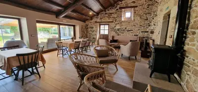 a restaurant with tables and chairs and a brick wall at Habitaciones La Cuevona de Guitiriz,Parga, en el camino norte Lugo in Parga