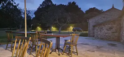 a patio with a table and chairs in a yard at Habitaciones La Cuevona de Guitiriz,Parga, en el camino norte Lugo in Parga