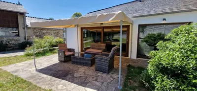 a patio with a table and chairs under an umbrella at Habitaciones La Cuevona de Guitiriz,Parga, en el camino norte Lugo in Parga