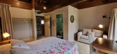 a bedroom with a bed and a couch and a table at Habitaciones La Cuevona de Guitiriz,Parga, en el camino norte Lugo in Parga