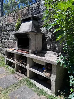 a stone oven sitting next to a stone wall at Casa 2 habitaciones con piscina y cenador al aire libre in Pontevedra