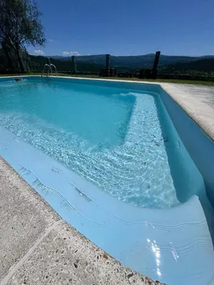 a blue swimming pool with water in it at Casa 2 habitaciones con piscina y cenador al aire libre in Pontevedra