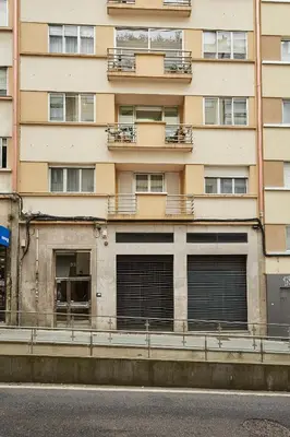 a tall building with three garage doors in front of it at Vut Salvador Santiago in Santiago de Compostela