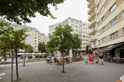 a city street with people and tables and buildings at Vut Salvador Santiago in Santiago de Compostela