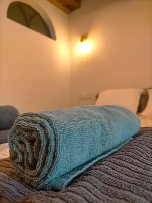 a blue towel sitting on the edge of a bed at Granja Labrada: Alojamiento con caballos in Santa María