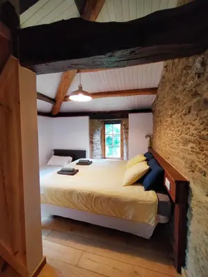 a bedroom with a large bed in a brick wall at Granja Labrada: Alojamiento con caballos in Santa María