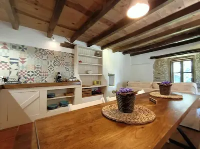 a living room with a wooden table with flowers on it at Granja Labrada: Alojamiento con caballos in Santa María