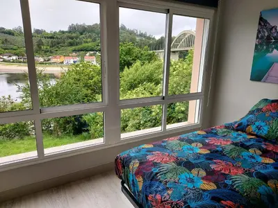 a room with three windows and a couch in front thereof at Apartamento Vistas Pedrido in Paderne