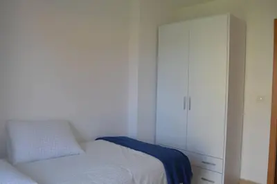 a bedroom with a bed and a white cabinet at Precioso apartamento con garaje en Ares. in Ares