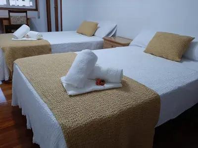 a room with two beds with towels on them at Pensión A Fonte in Caldas de Reis