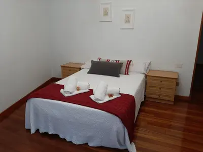 a bedroom with a white bed with towels on it at Pensión A Fonte in Caldas de Reis