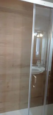 a bathroom with a glass shower with a sink at Pensión A Fonte in Caldas de Reis