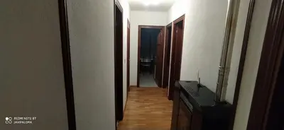 a hallway leading to a room with a television and a door at Apartamentos xistra in Cangas del Narcea
