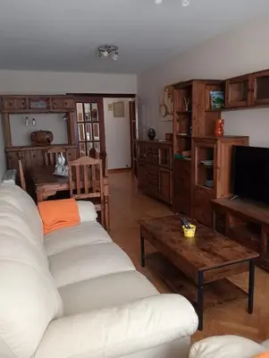 a living room with two white couches and a television at Apartamentos xistra in Cangas del Narcea