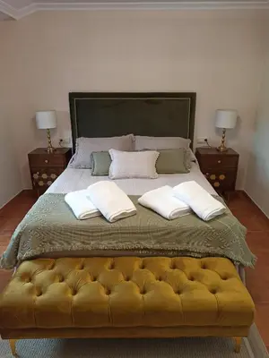 a bedroom with a large bed with two night stands at A casiña de Estela in Caldas de Reis