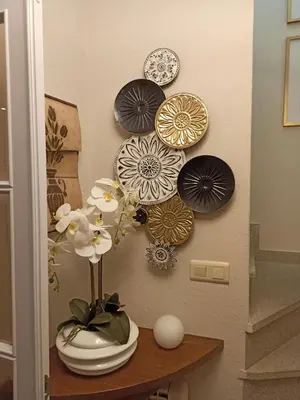 a shelf with plates and flowers on a wall at A casiña de Estela in Caldas de Reis