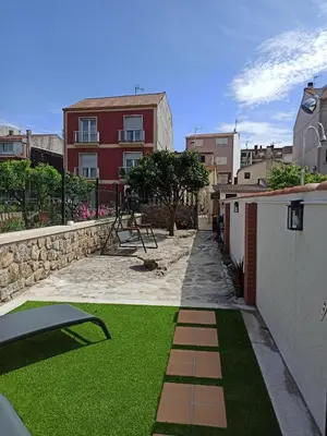a small yard with green grass and a building at A casiña de Estela in Caldas de Reis