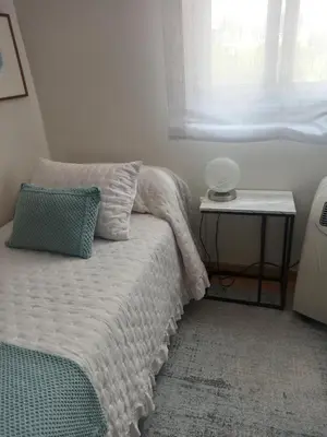 a bedroom with a bed and a table with a window at A casiña de Estela in Caldas de Reis