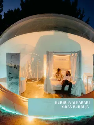 two women sitting on a bed in a round room at Burbujas Astronómicas Albarari Coruña in Oleiros
