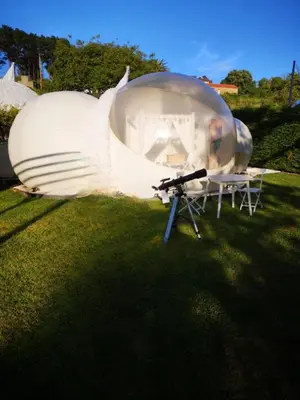 a person in a glass dome on the grass at Burbujas Astronómicas Albarari Coruña in Oleiros