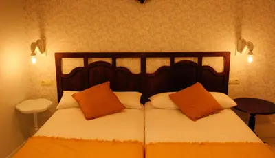 a bedroom with a bed with orange and white pillows at Casa Meiga in Arzúa