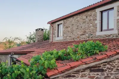 a brick house with a vegetable garden on the roof at Casa Meiga in Arzúa