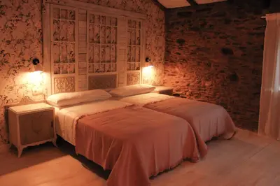 a bedroom with a bed and a brick wall at Casa Meiga in Arzúa