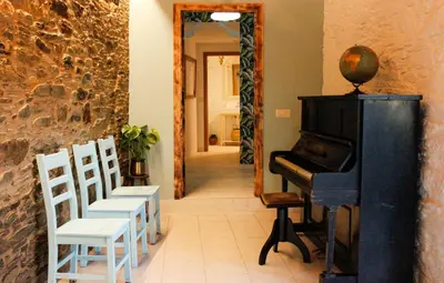 a room with a piano and chairs and a hallway at Casa Meiga in Arzúa
