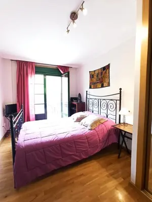 a bedroom with a bed with a purple bedspread at Indiano 1K in Viveiro