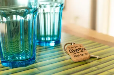 a small key on a table with two blue vases at O Lar do Camiñante in Palas de Rei