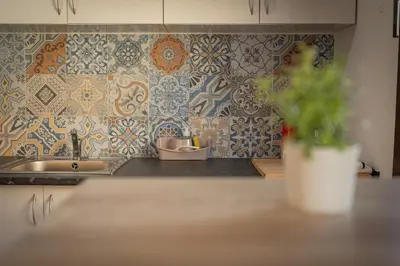 a kitchen with a sink and a tile wall at O Lar do Camiñante in Palas de Rei