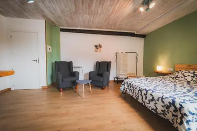 a bedroom with two chairs and a bed and a table at O Noso Recuncho in Palas de Rei