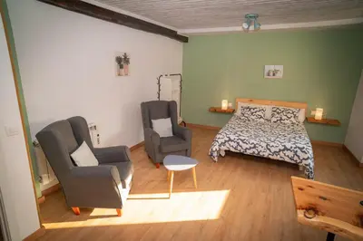 a bedroom with a bed and two chairs and a bed and a couch at O Noso Recuncho in Palas de Rei