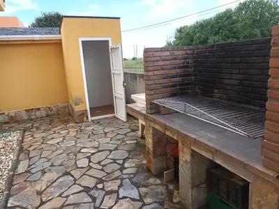 a patio with a brick wall and a grill at Casa Icaro in Barreiros