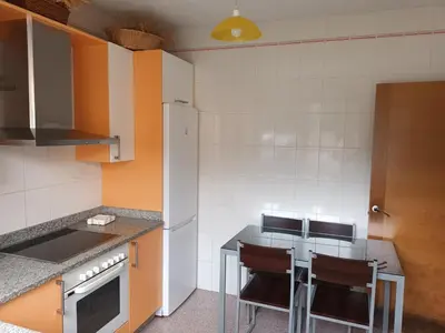 a kitchen with orange and white walls and a counter at Casa Icaro in Barreiros