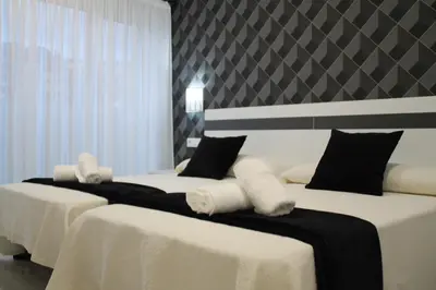 two beds in a room with white sheets and pillows at Baixo a Lua Rooming in Sarria