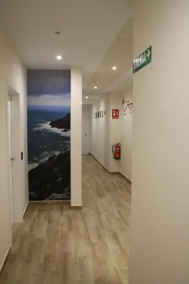 an empty hallway with a painting on the wall at Baixo a Lua Rooming in Sarria