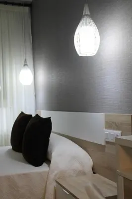 a bedroom with two pillows on a bed with two lights at Baixo a Lua Rooming in Sarria
