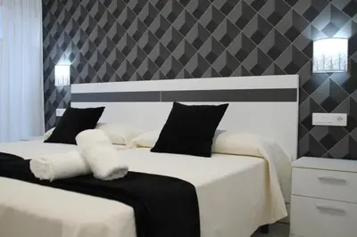 two beds in a bedroom with black and white at Baixo a Lua Rooming in Sarria
