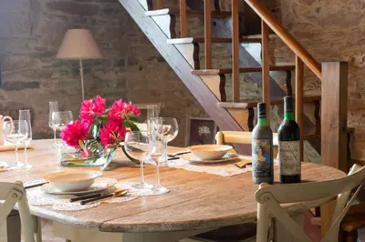 a wooden table with wine glasses and flowers on it at Casa Quinta de Cecil in Villalba