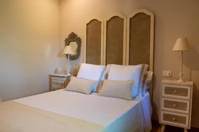 a bedroom with a bed with a headboard and two pillows at Casa Quinta de Cecil in Villalba